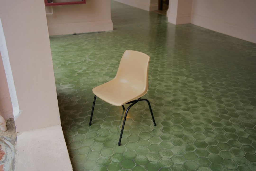 A white chair sitting on top of a green floor in Allen, TX
